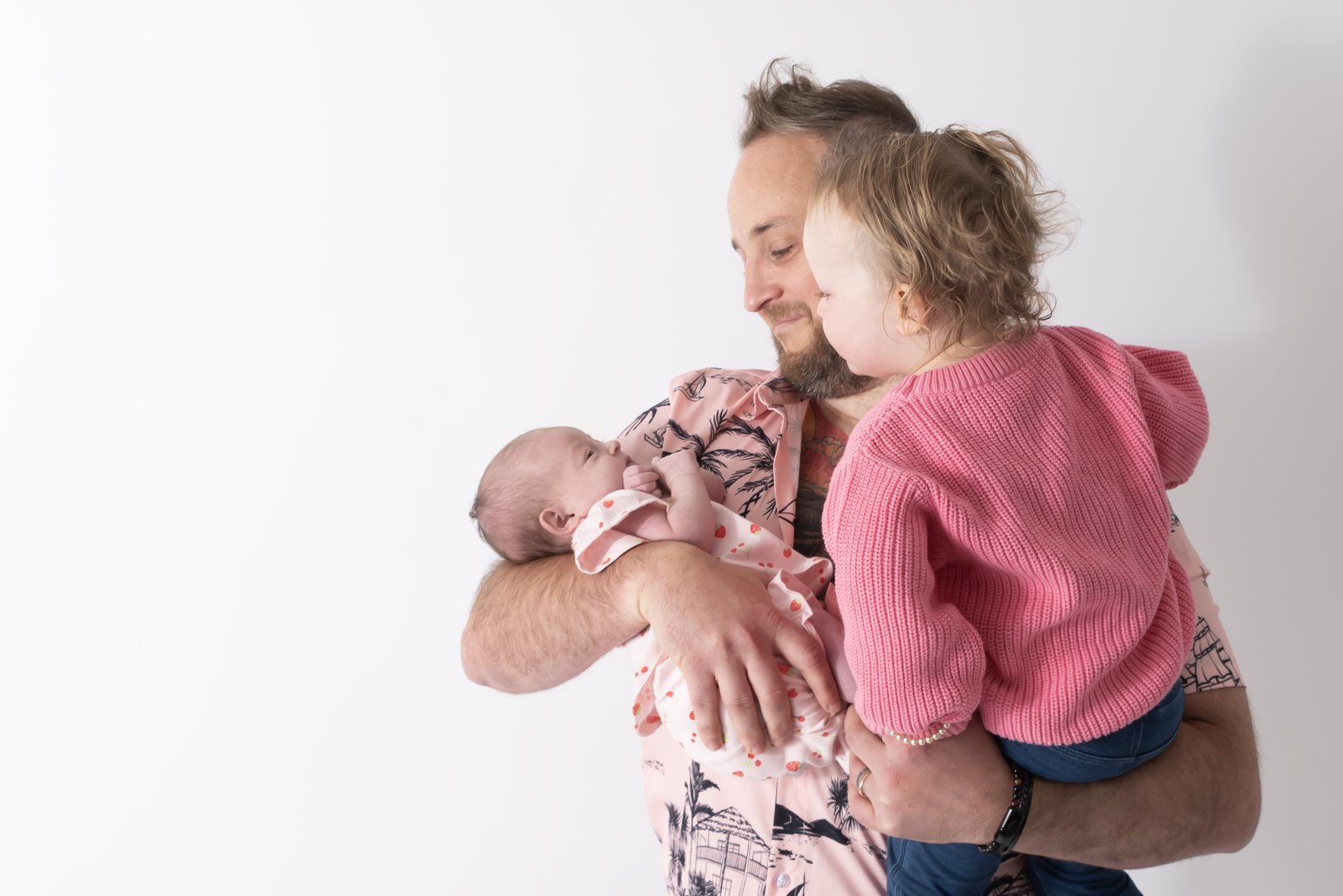 Chris holding his newborn daughter and toddler